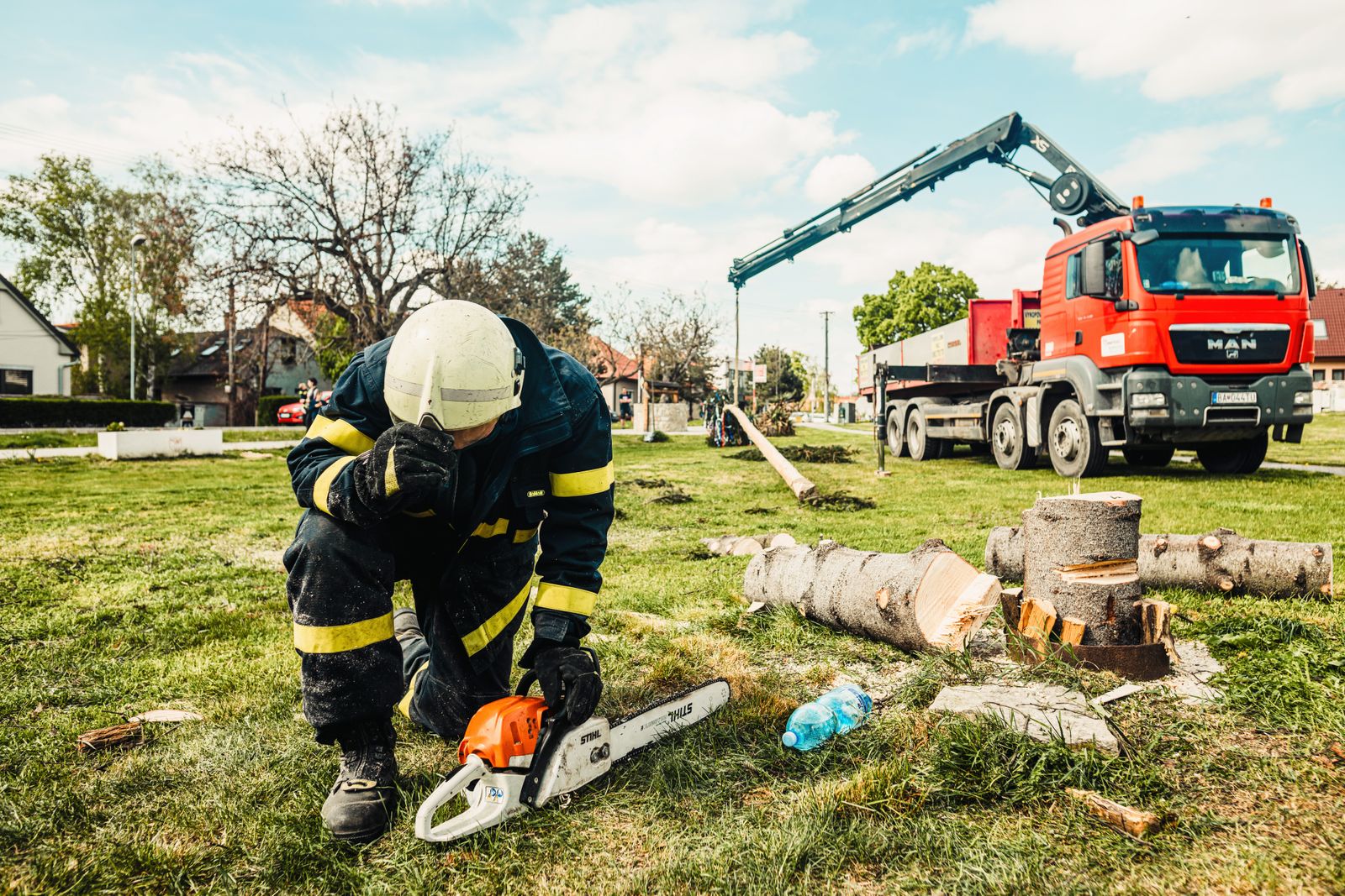Timberline arborist cutting a trunk beside a crane truck